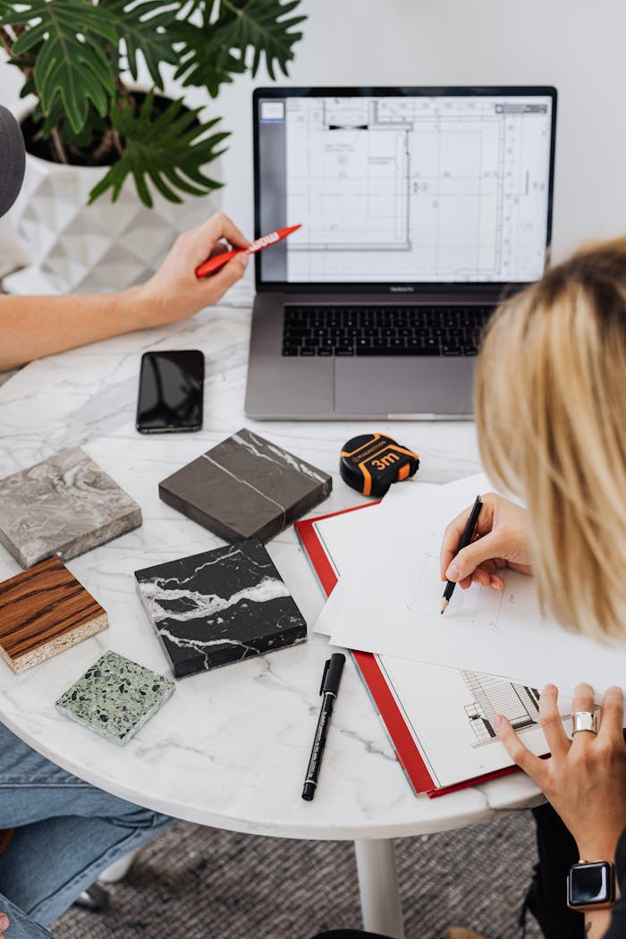 about-01 Creative professionals designing interior spaces with laptop and material samples at a modern work table.