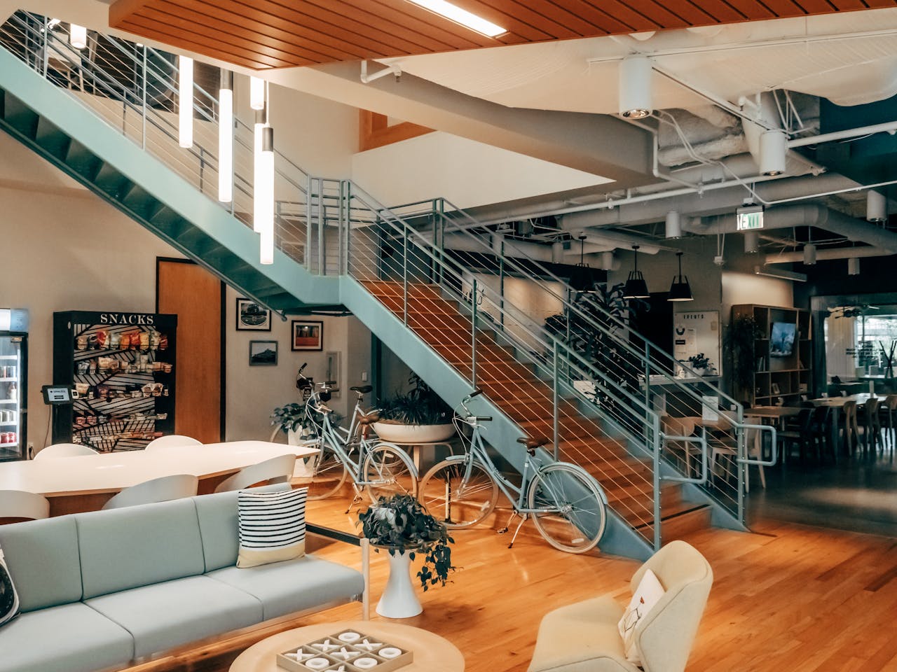 testimonials-img A contemporary open office space with bicycles, sofas, and a snack area, showcasing modern interior design.