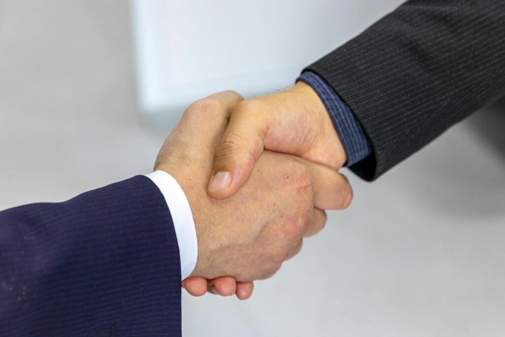Close-up of two businessmen shaking hands, symbolizing agreement and partnership.
